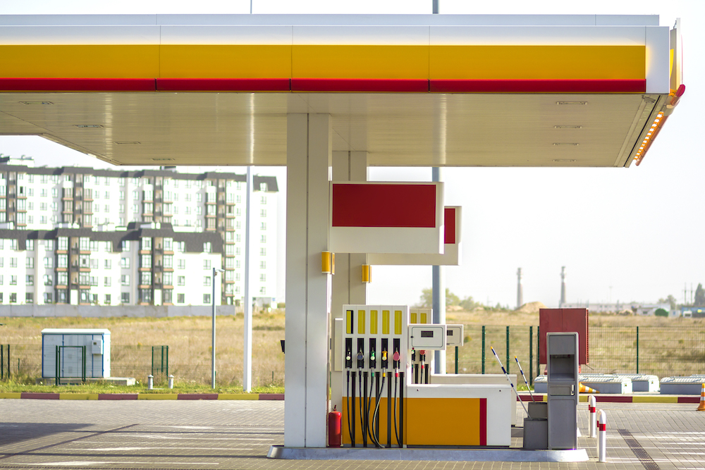 Clean empty auto gas station exterior on sunny day on rural landscape and bright sky copy space background.